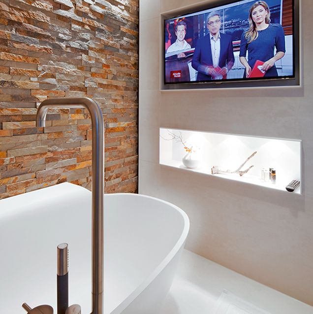 freistehende weiße Badewanne mit dekorativer Rückwand in Brickoptik
