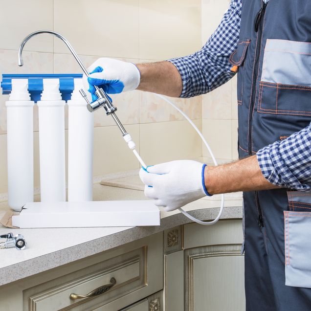 Wasserfiltersystem wird von Handwerker installiert