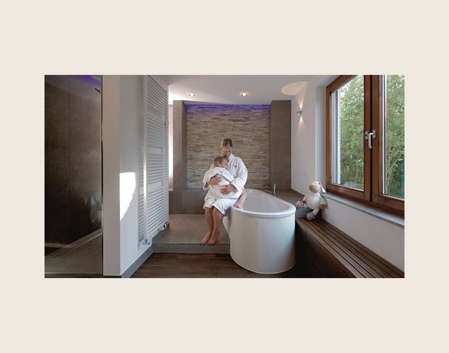 Freistehende Badewanne mit Holzbank und Fliesen in Steinoptik