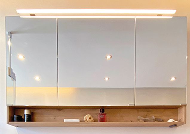 Badezimmerwaschtisch mit Spiegelschrank und fugenloser Wand im Hintergrund