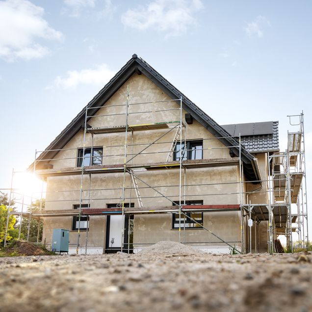 Baustelle mit Neubauhaus und Baugerüst