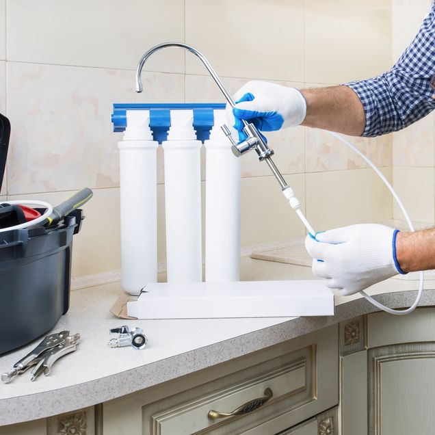 Wasserfiltersystem wird von Handwerker installiert