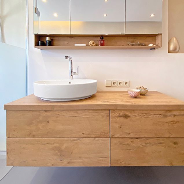 Badezimmerwaschtisch mit Spiegelschrank und fugenloser Wand im Hintergrund