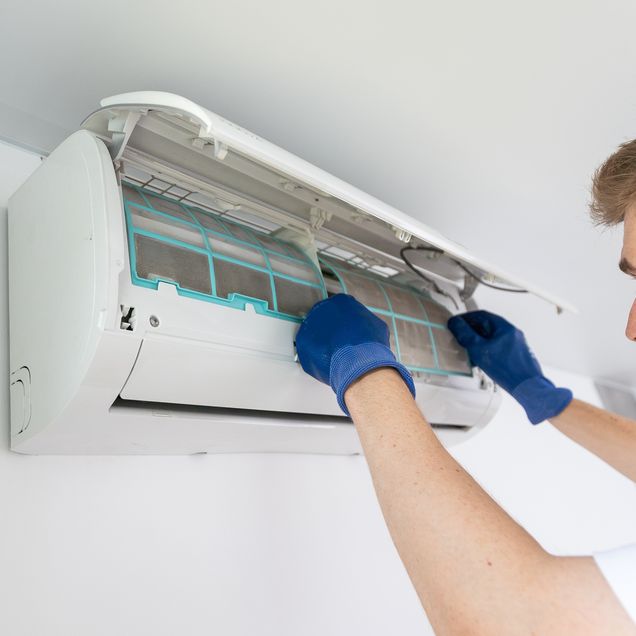 Techniker bei der Inspektion und Reparatur einer Klimaanlage.